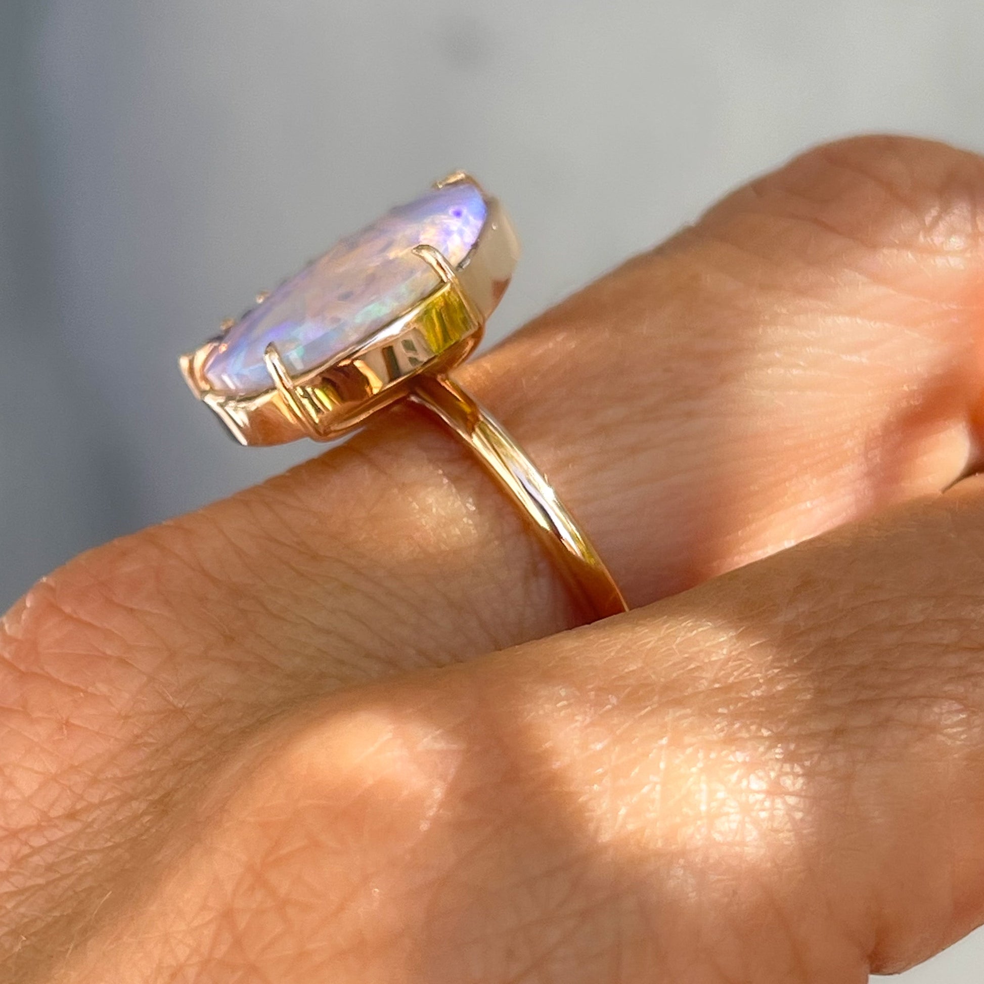 Profile shot of an Australian Opal Ring by NIXIN Jewelry. The image shows the claw prong setting of the natural opal stone.