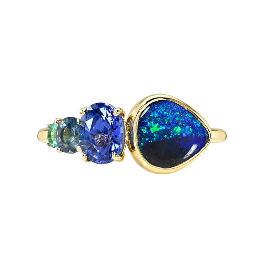 An Australian Opal Ring by NIXIN Jewelry. This studio image shows the modern design of the cocktail ring. The opal ring is a bold statement piece, combining a black opal with the cool tones of sapphires.