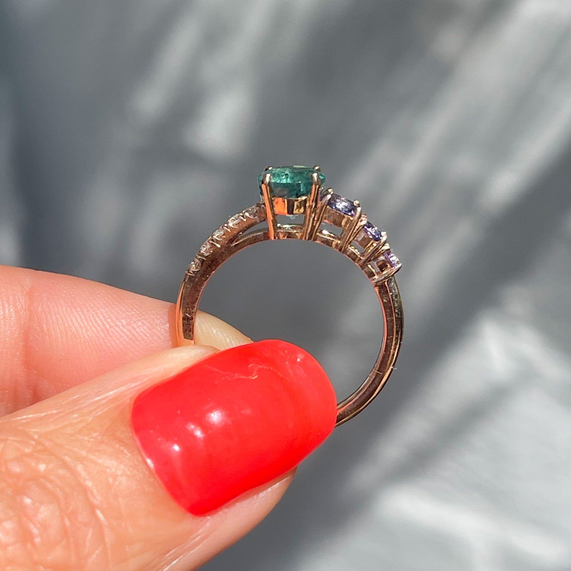 A Colombian Emerald Ring by NIXIN Jewelry shown in full profile. The one of a kind green emerald ring is set in 14k rose gold.