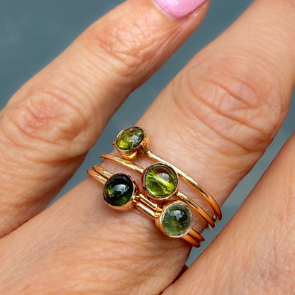 Lucky Green Tourmaline Rings stacked on the finger, four dainty rings in olive, chartreuse, deep forest and sage green.