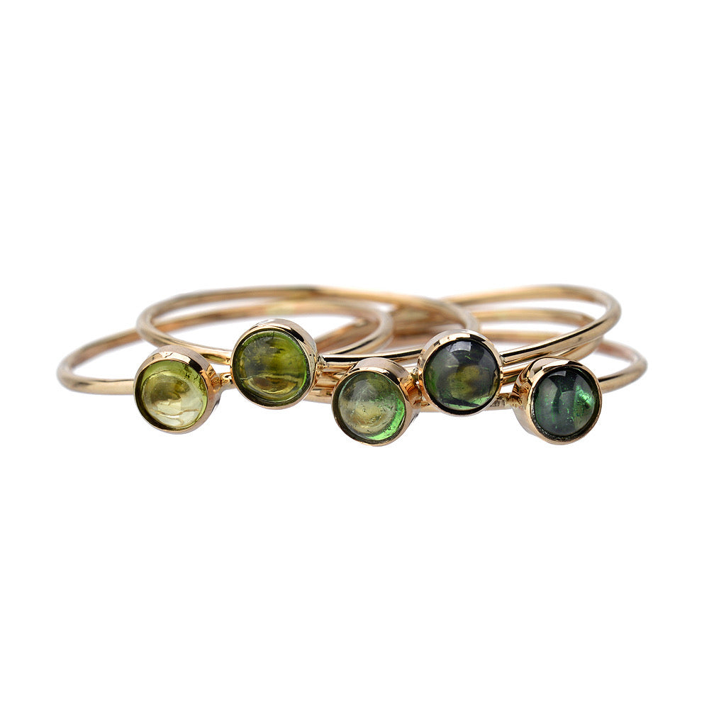 Lucky Green Tourmaline Rings by NIXIN Jewelry: five tourmaline cabochon stacking rings in 14k gold, pale chartreuse to deep forest green.