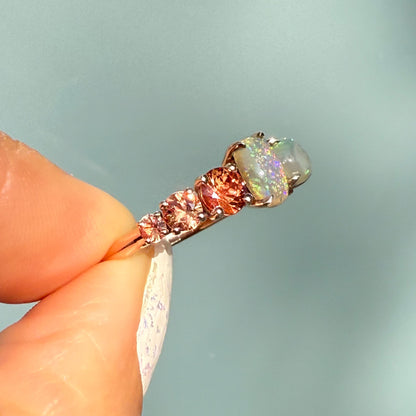 An Australian Opal Ring by NIXIN Jewelry viewed from the side, demonstrating the height and placement of the prong setting for maximum light exposure. The two lightning ridge opal gems are perfectly positioned with the contrasting sapphires. This women's luxury ring is guaranteed authentic australian opal.