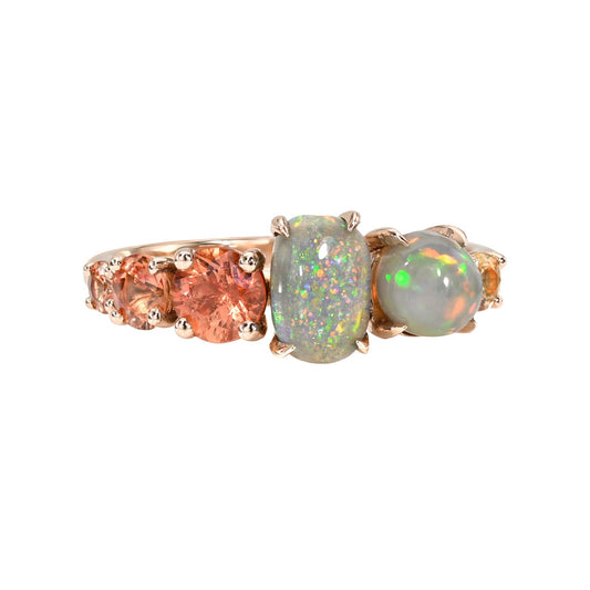 An Australian Opal Ring by NIXIN Jewelry with Lightning Ridge Opals and sapphires. The rose gold opal ring holds two semi black opals in prong settings. A stunning design for an opal jewelry collector.