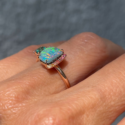 Side view of an Australian Opal Ring by NIXIN Jewelry. Photo shows the blue opal in a prong setting and the rainbow sapphires.