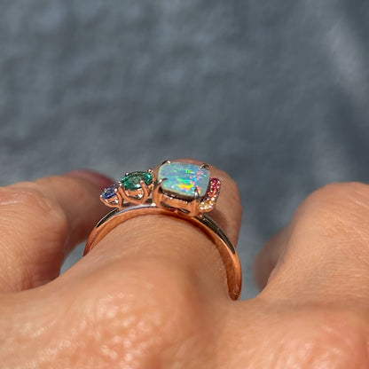 Profile shot of an Australian Opal Ring by NIXIN Jewelry. Shows the emerald and opal ring set in rose gold.