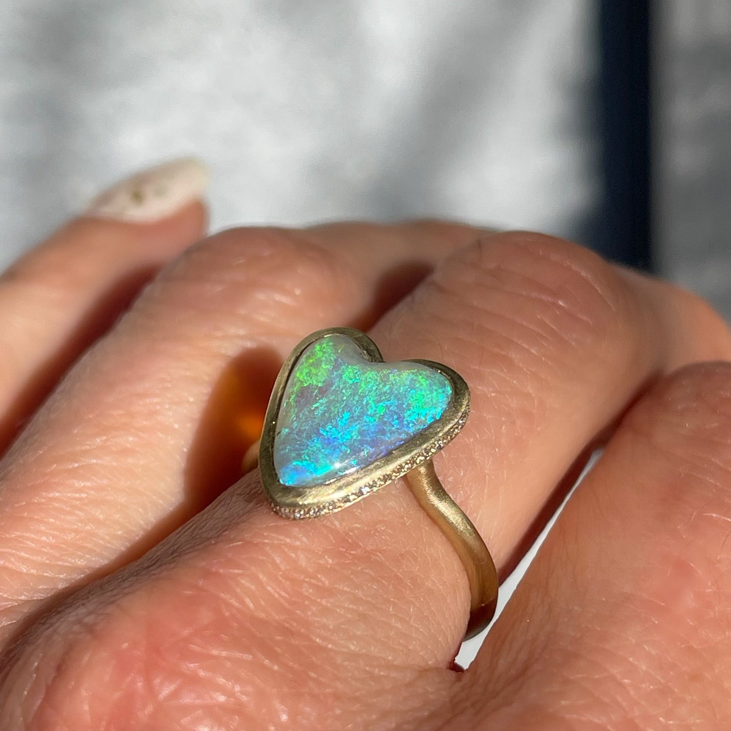Side view of an Australian Opal Ring by NIXIN Jewelry showing the pave diamonds around the opal ring.