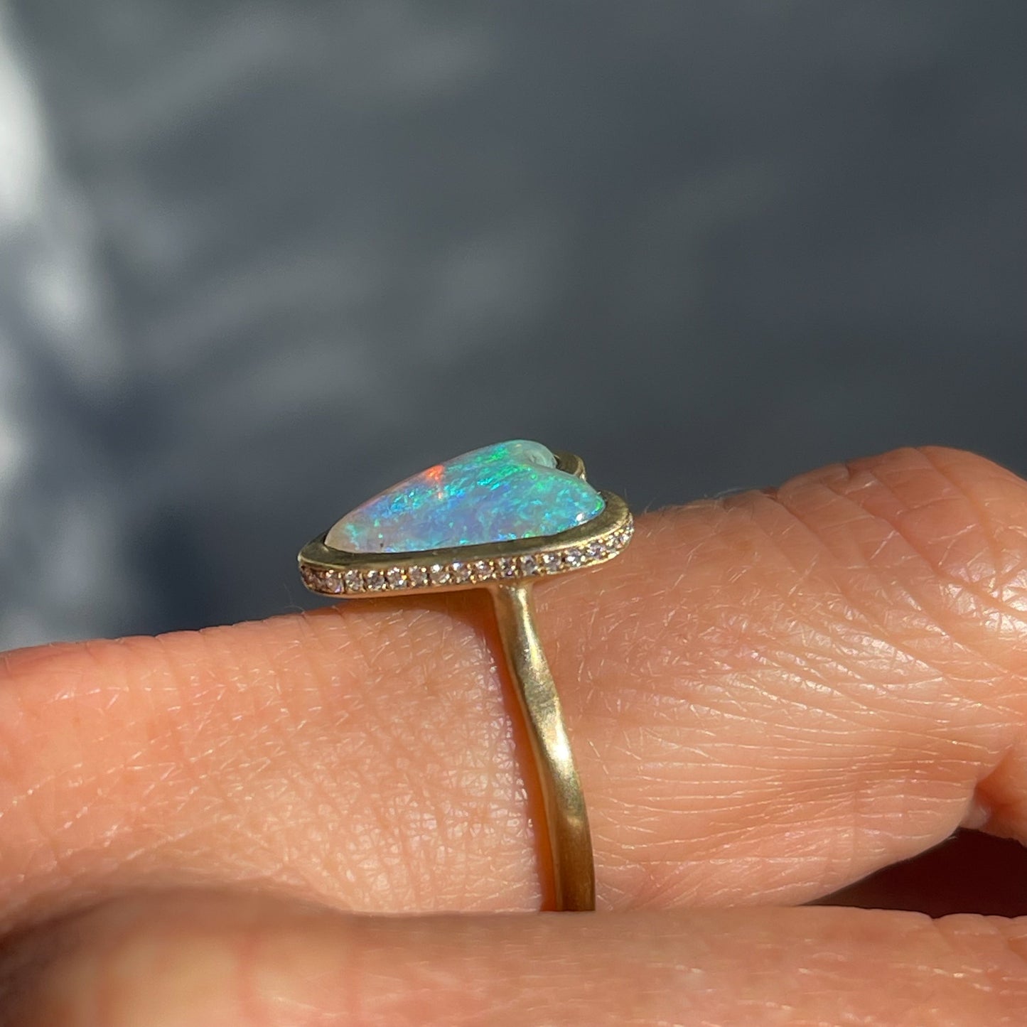 Profile shot of an Australian Opal Ring by NIXIN Jewelry in gold. An opal ring with diamonds.