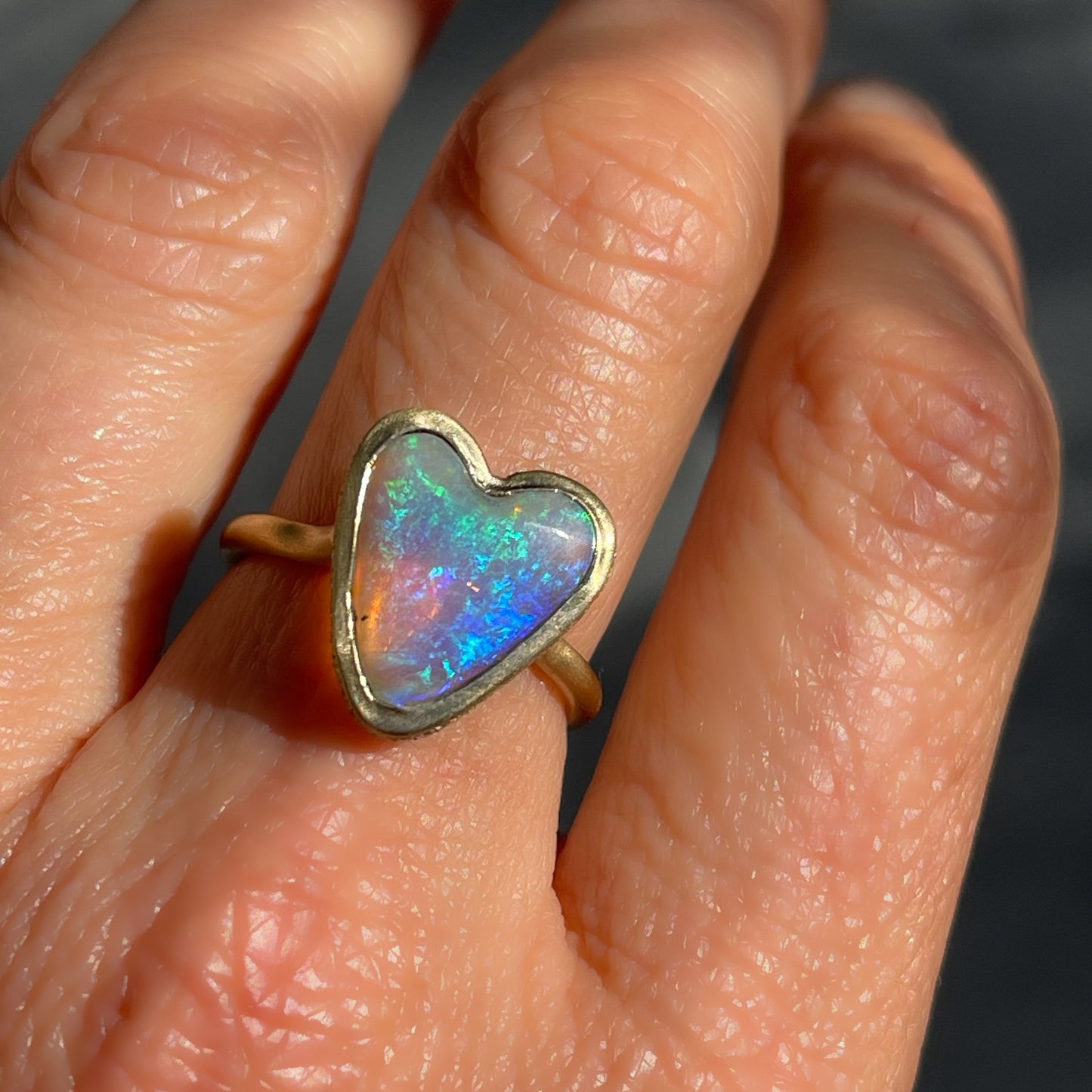 An Australian Opal Ring by NIXIN Jewelry with an opal heart and diamond halo set in 14k gold.
