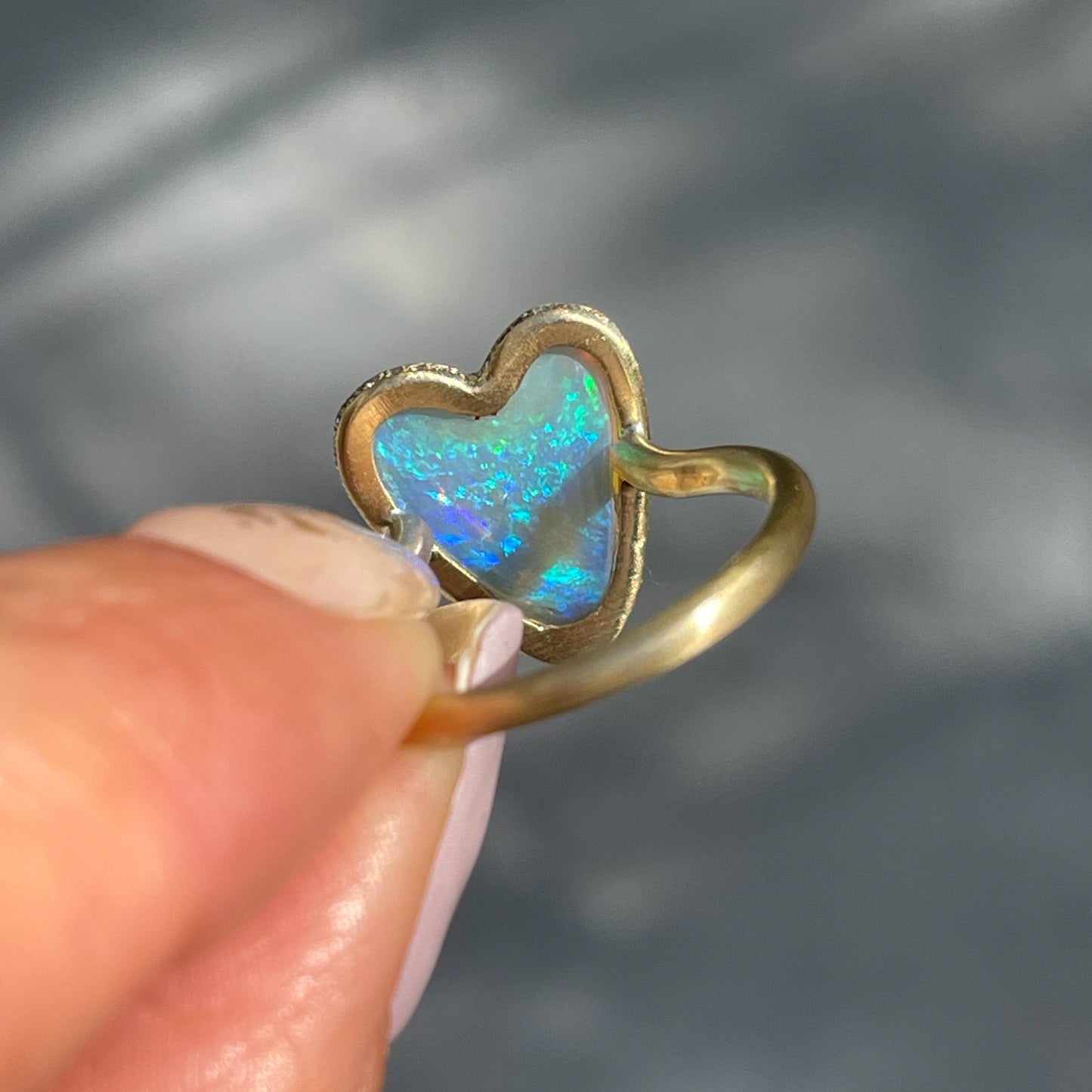 View of the back of an Australian Opal Ring by NIXIN Jewelry with an opal heart set in yellow gold.