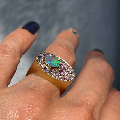 An Australian Opal Ring by NIXIN Jewelry worn on the hand and shown in profile. A gold opal signet ring with a blue green opal and ombre sapphires.