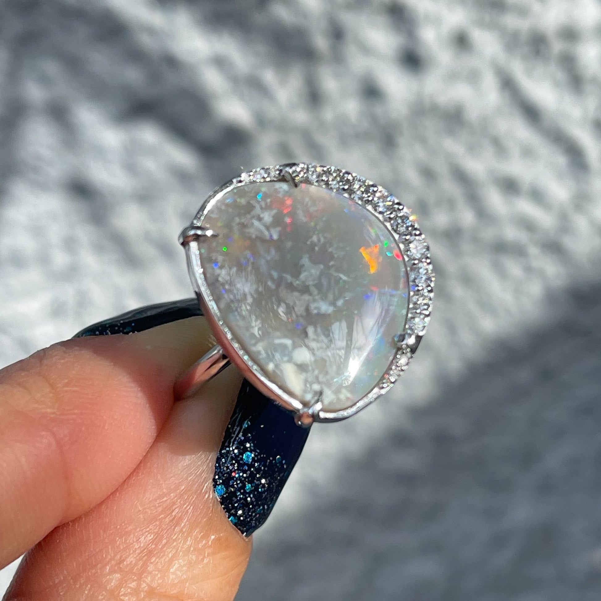 Side view of an Australian Opal Ring by NIXIN Jewelry with a Lightning Ridge Black Opal set in 14k white gold.