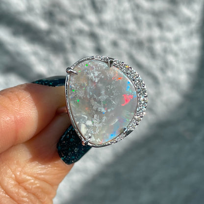 An Australian Opal Ring by NIXIN Jewelry with a partial diamond halo around a Black Opal.