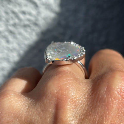 An Australian Opal Ring by NIXIN Jewelry made in white gold with diamonds shown low in profile on the hand.