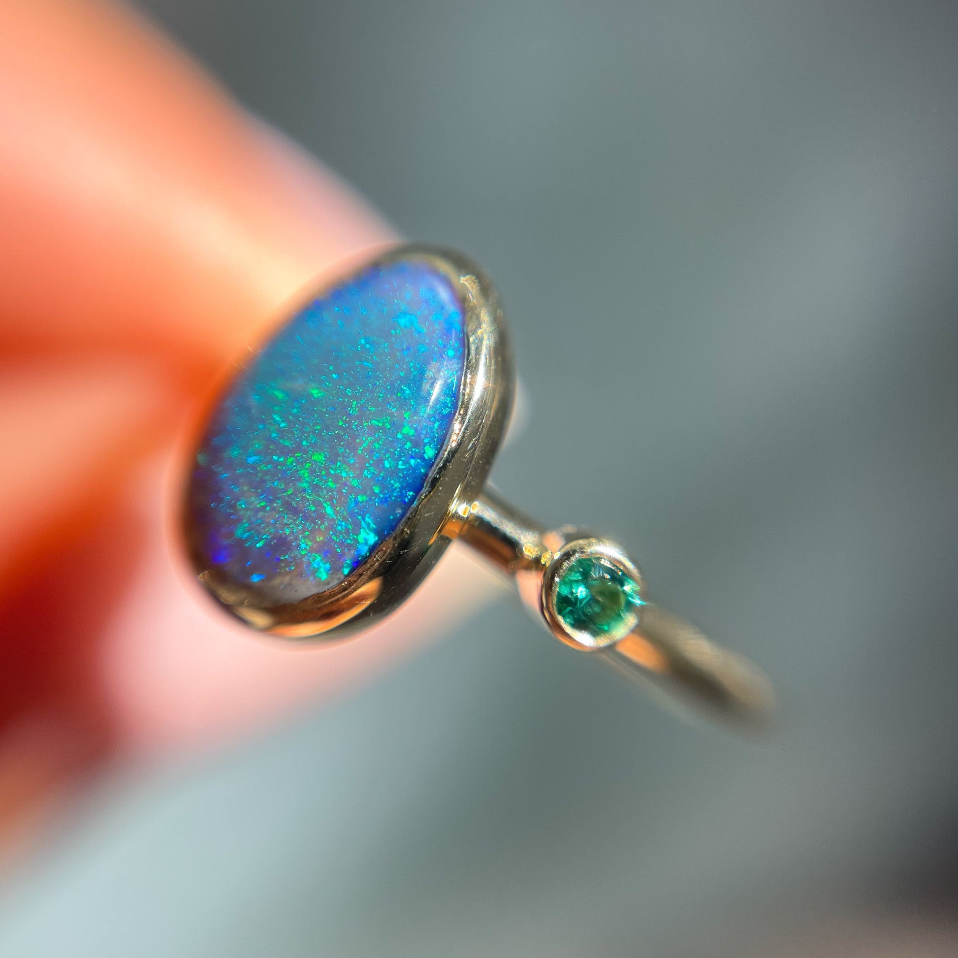 Close up of an Australian Opal Ring by NIXIN Jewelry. Shows the emerald in the black opal ring.