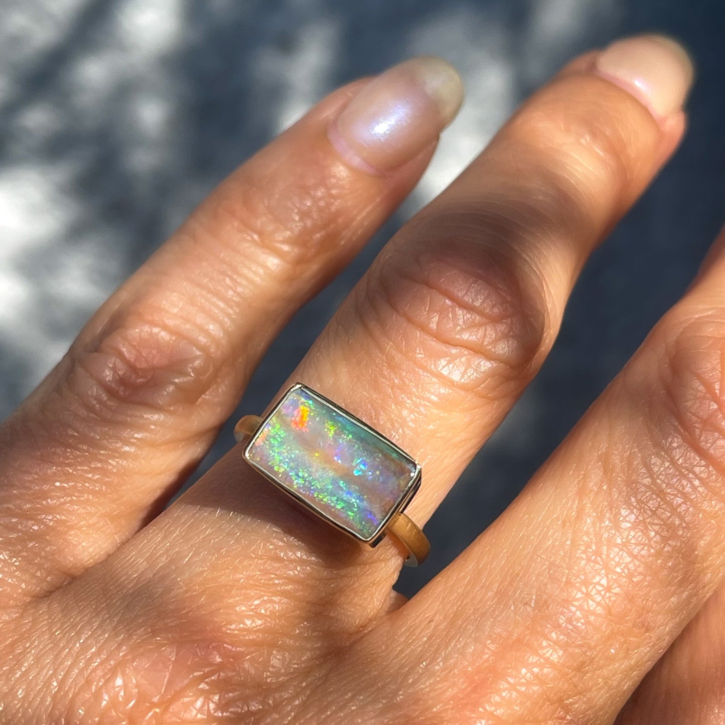 An Australian Opal Ring by NIXIN Jewelry modeled with a Pipe Boulder Opal set in yellow gold.