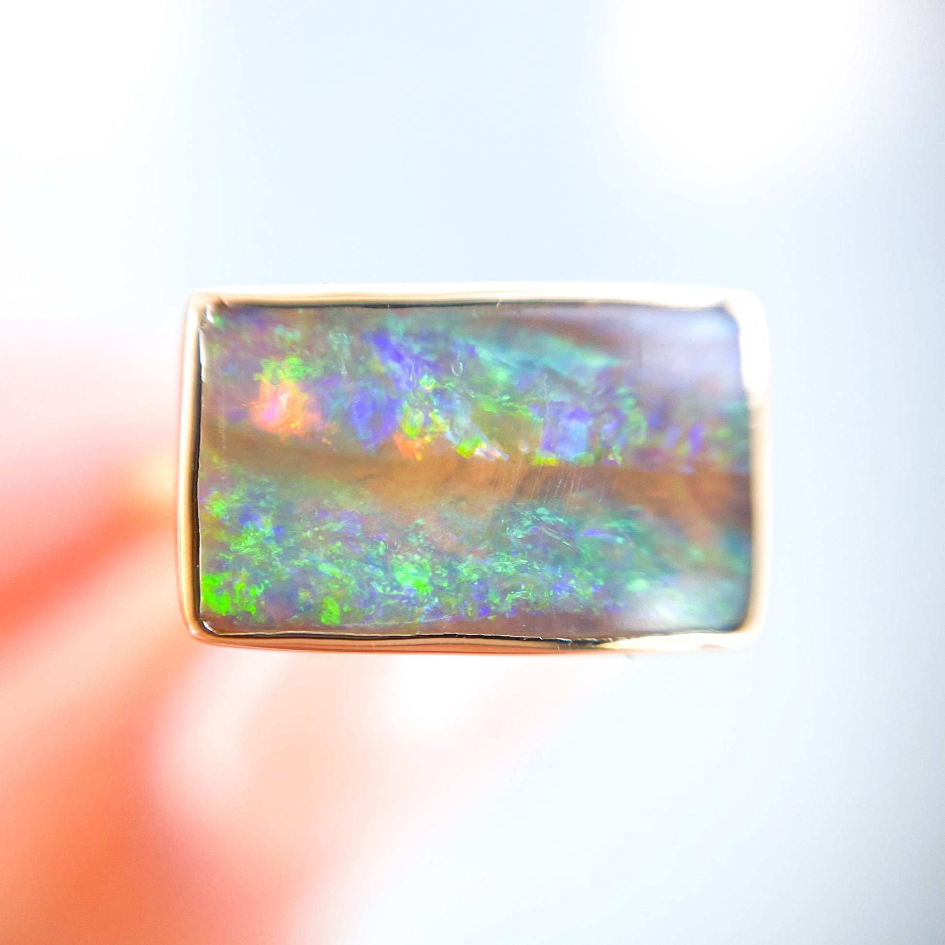 Close up of an Australian Opal Ring by NIXIN Jewelry showing rainbow flashes on the green opal.