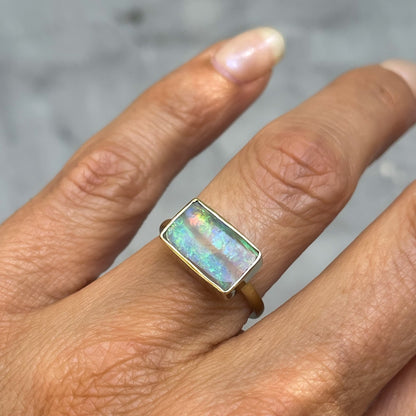 An Australian Opal Ring by NIXIN Jewelry modeled with a blue green opal in a real opal ring.