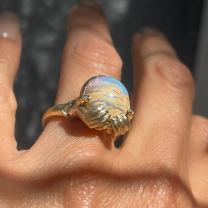 An Australian Opal Ring by NIXIN Jewelry modeled on the hand. Shows the Boulder Opal set in 14k gold.