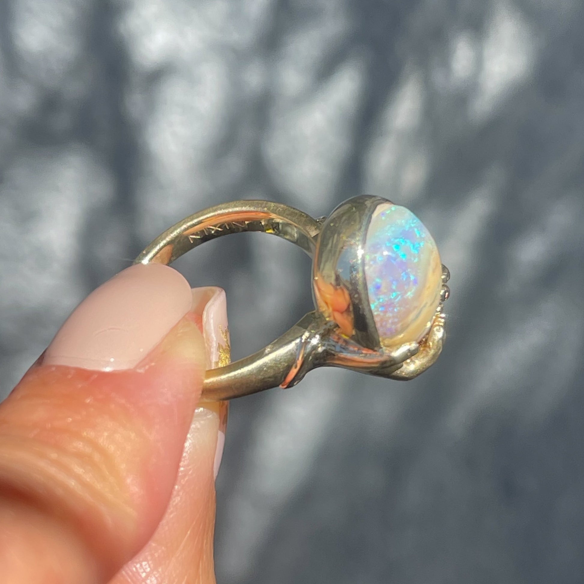 Angled view of an Australian Opal Ring by NIXIN Jewelry. Handmade jewelry in 14k gold.