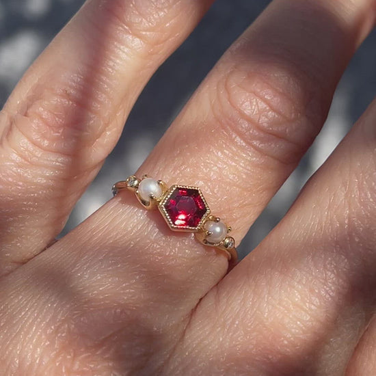 Video of gold garnet ring by NIXIN Jewelry worn on model's hand