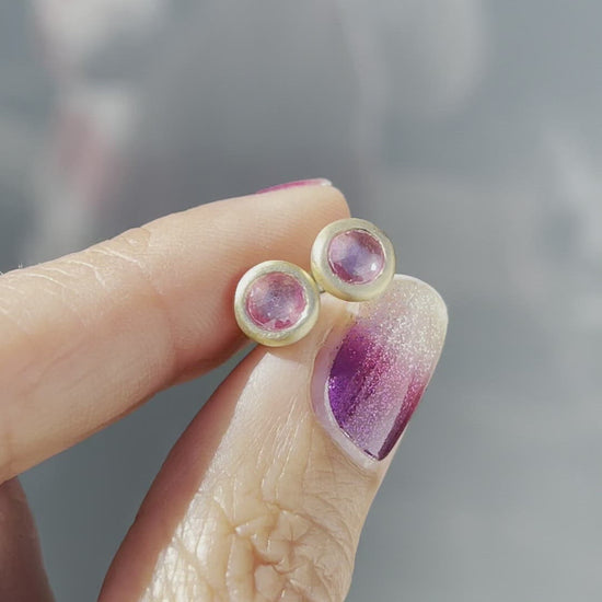 Video of pink sapphire earrings by NIXIN Jewelry held in sunlight 