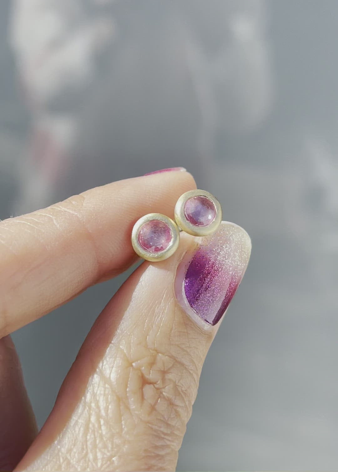 Video of pink sapphire earrings by NIXIN Jewelry held in sunlight 