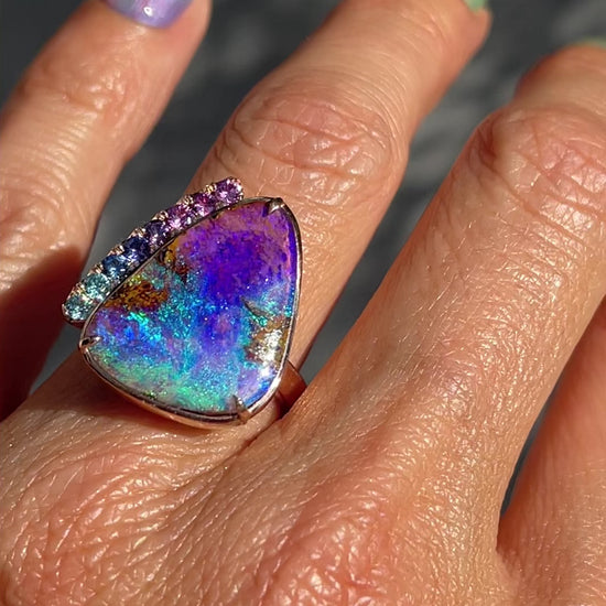 Video of an Australian Opal Ring by NIXIN Jewelry made with a Pipe Opal and Sapphires , on the model's hand.