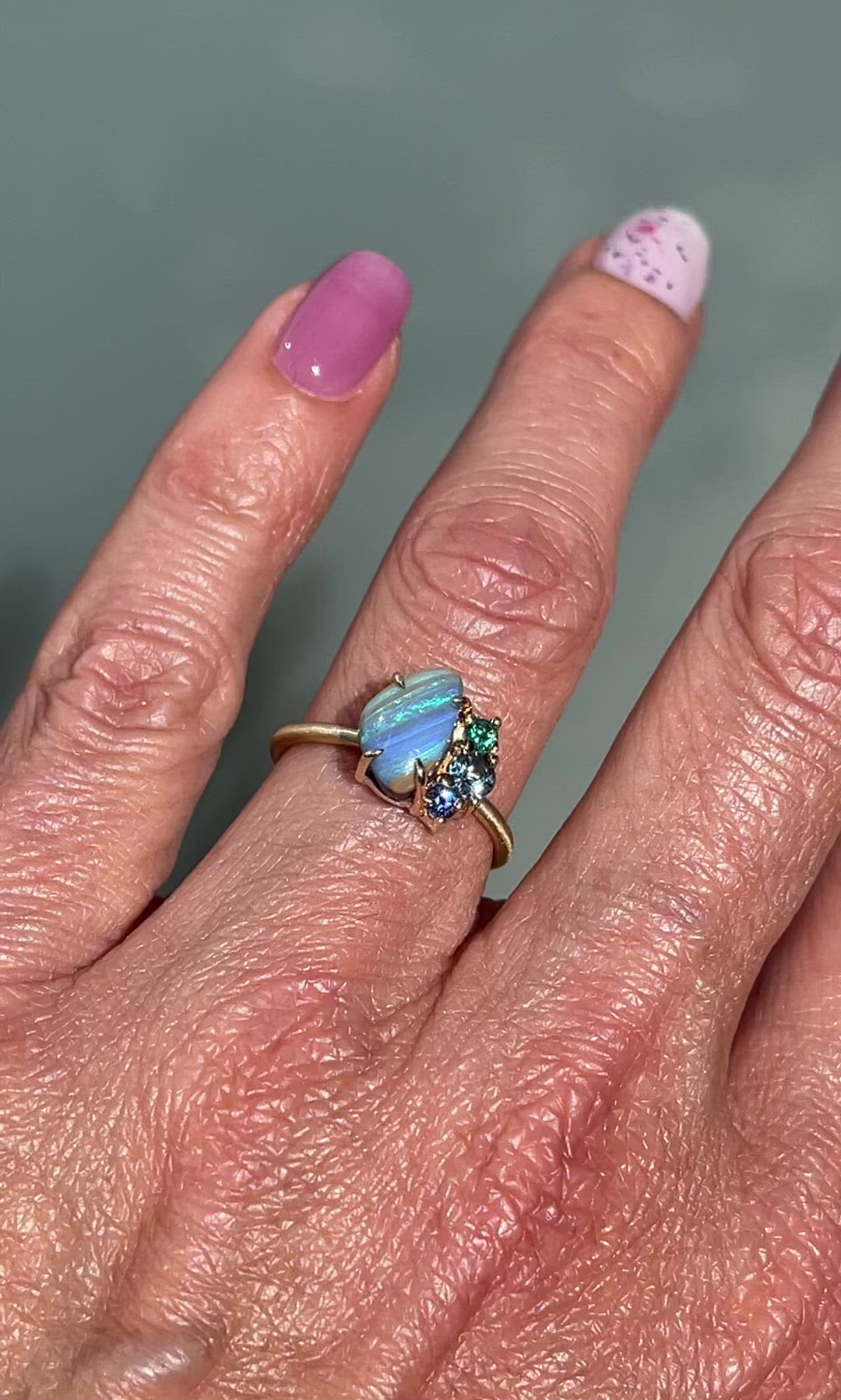 Video of Emerald and Opal Ring by NIXIN Jewelry. Australian opal ring with gemstones modeled on hand.