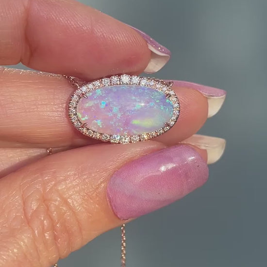 Video of an Australian Opal Necklace by NIXIN Jewelry held up in sunlight. A Crystal Opal Necklace set in rose gold with a diamond halo.