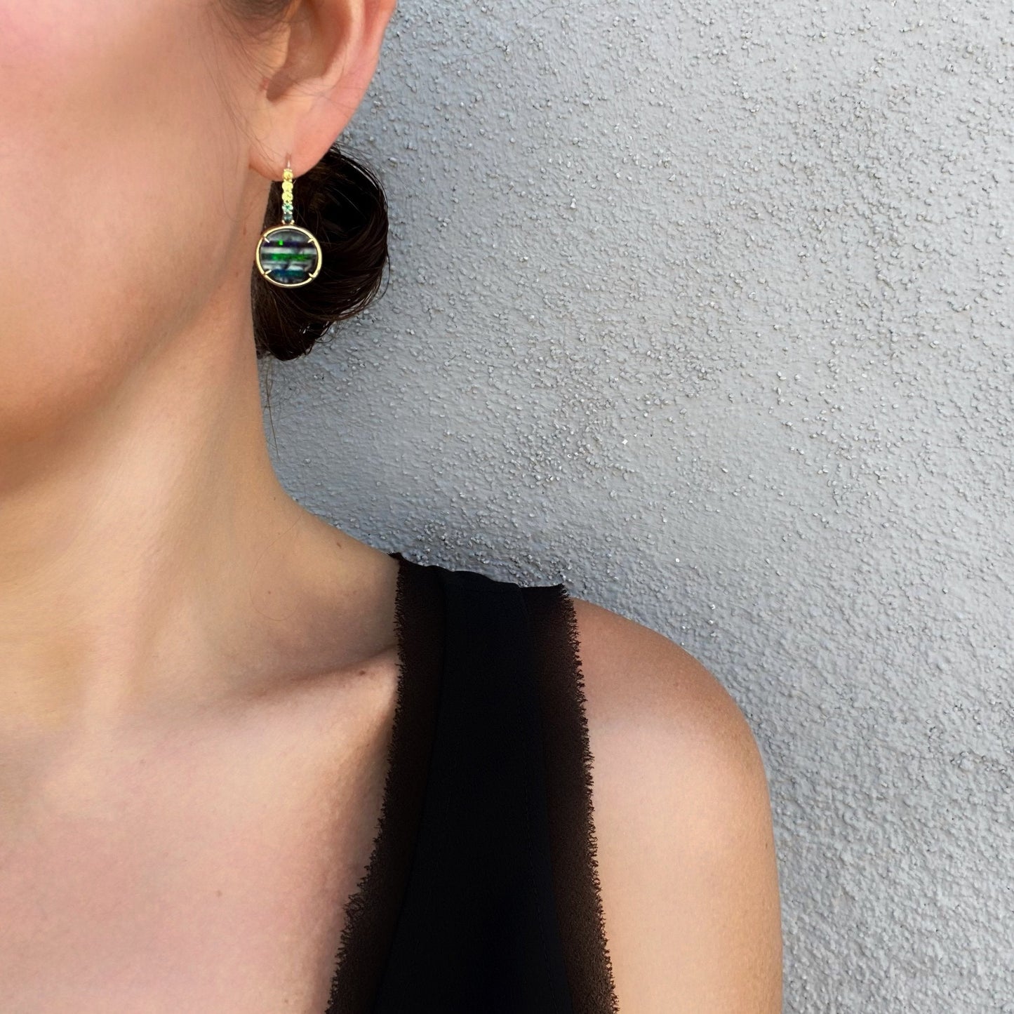 Model shot of green sapphire and gold opal earrings by NIXIN Jewelry