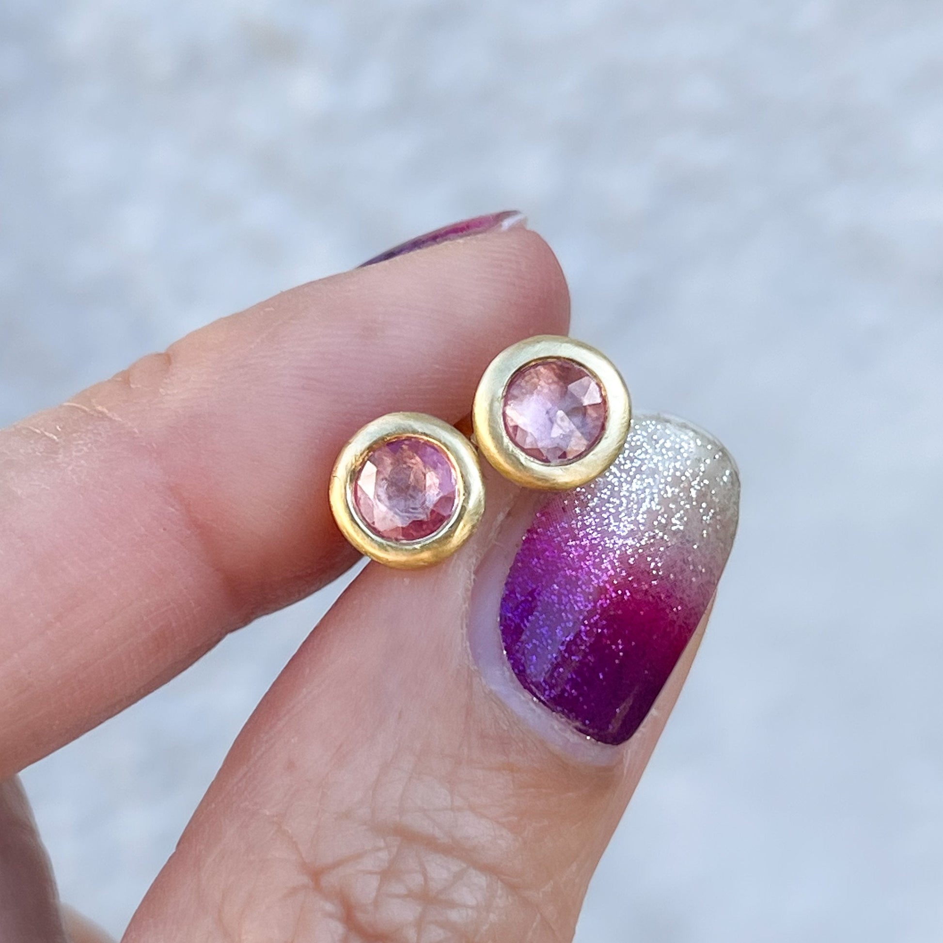 Pink sapphire studs by NIXIN Jewelry held in shade