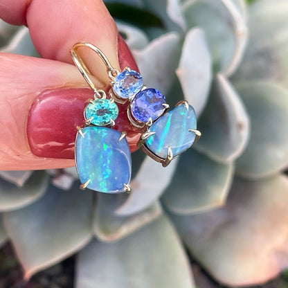 Australian Opal Earrings by NIXIN Jewelry held above a succulent. Opal and sapphire jewelry.