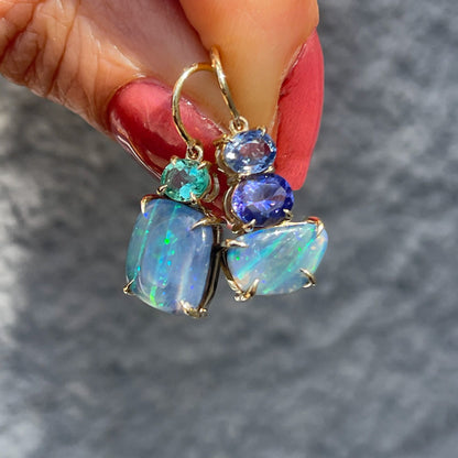 Australian Opal Earrings by NIXIN Jewelry held in sunlight. Blue opal earrings.