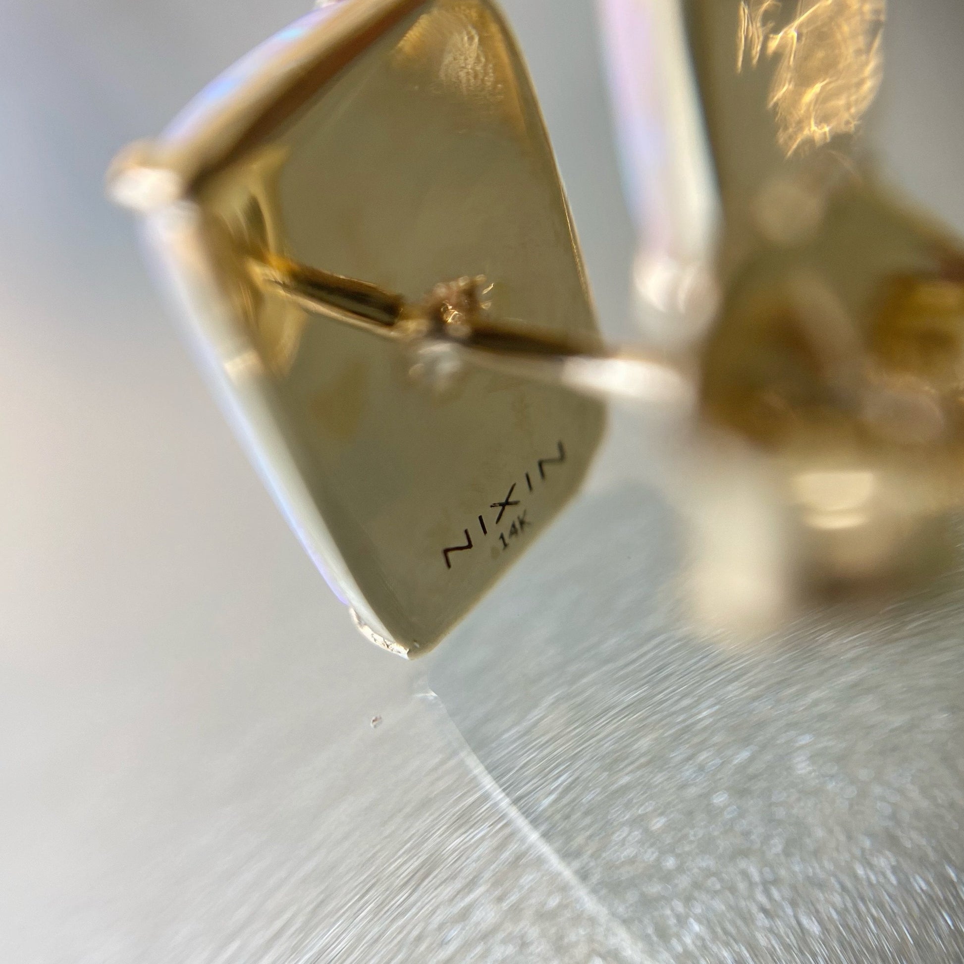 Close up of back of gold opal studs by NIXIN Jewelry