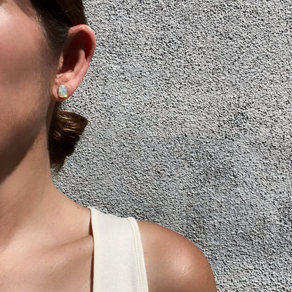 Model shot on ear of Asymmetrical earrings with crystal opal and diamonds by NIXIN Jewlery