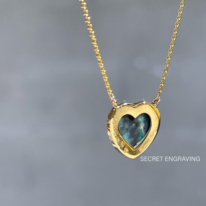 A view of the back of an Australian Opal Heart Necklace by NIXIN Jewelry. It shows the heart shape of the Black Opal.