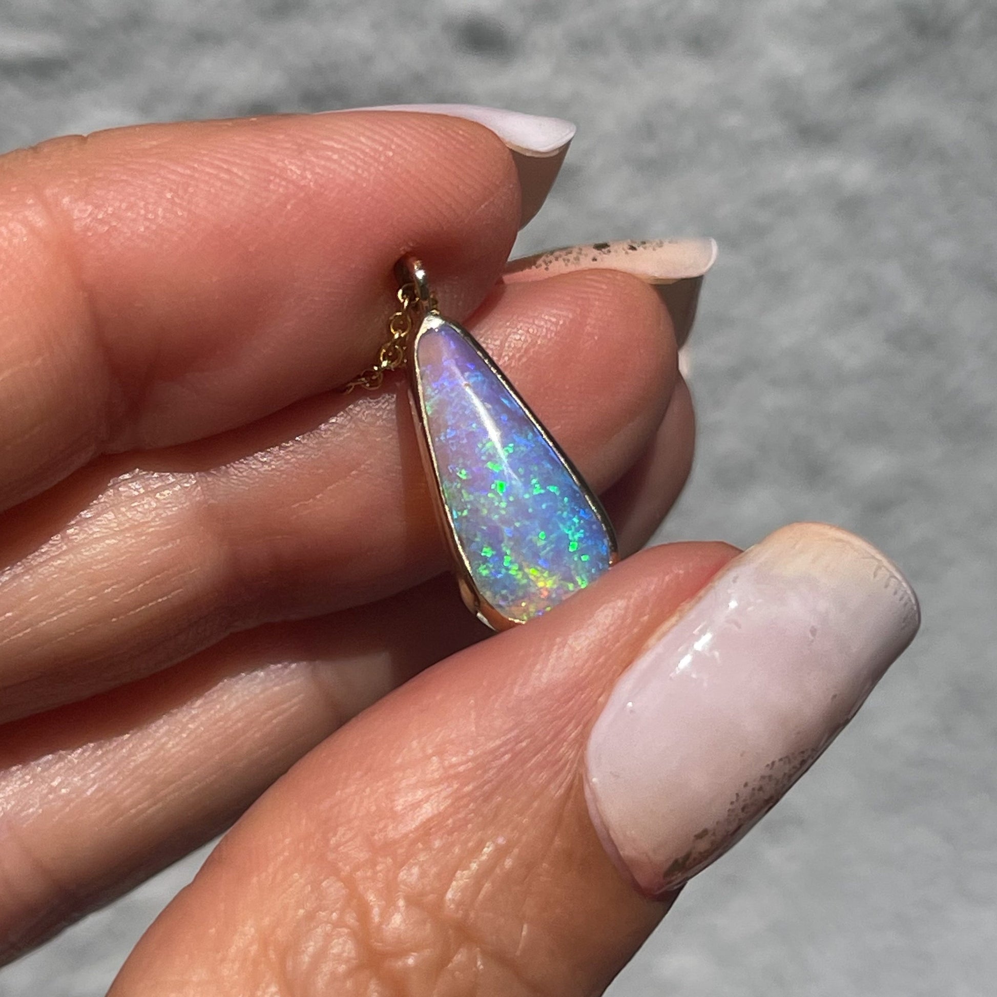 Australian Opal Necklace by NIXIN Jewelry held in sunlight. Crystal opal necklace.
