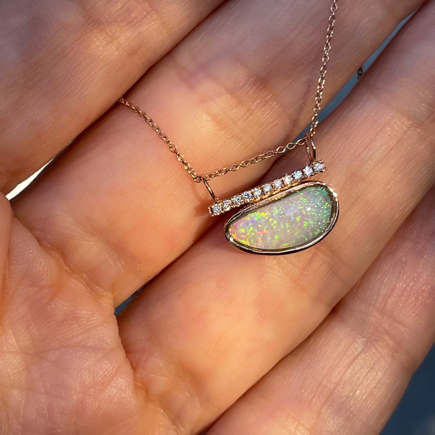 Coober Pedy opal necklace by NIXIN Jewelry shown against hand