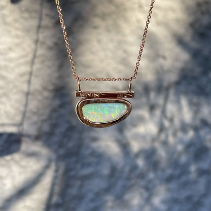 Rose gold opal necklace by NIXIN Jewelry shown from behind