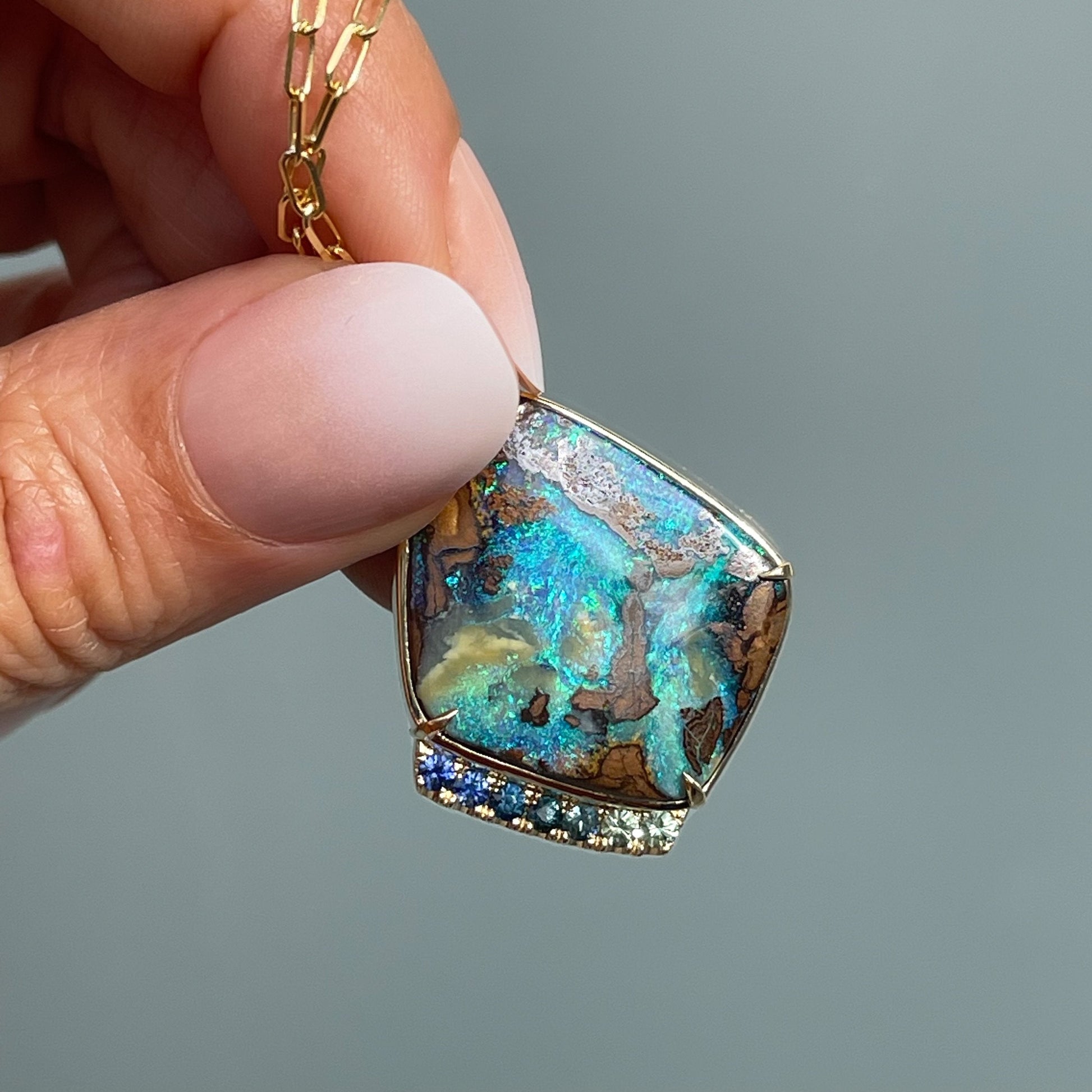 Green opal necklace by NIXIN Jewelry held in sunlight
