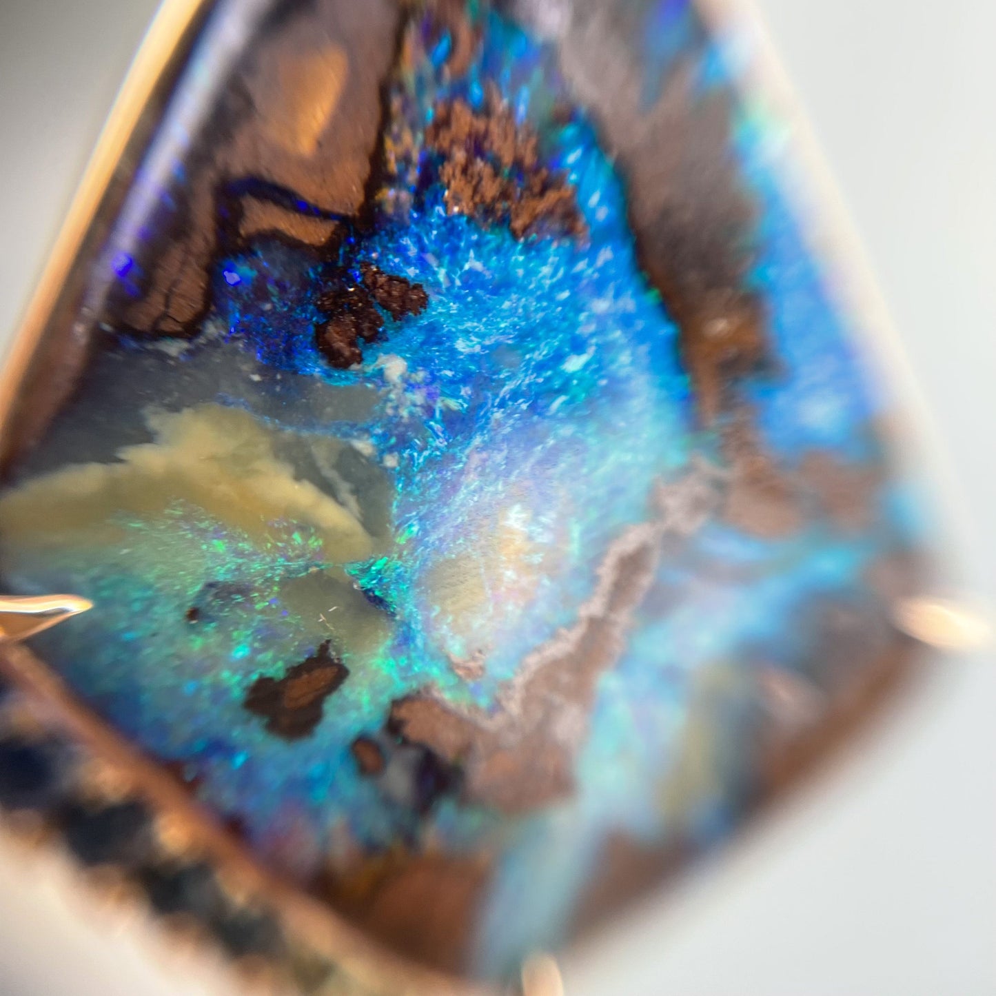 Australian Opal necklace set with claw prongs by NIXIN Jewelry shown under loupe