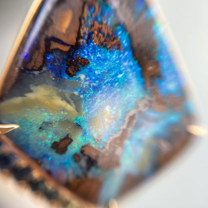 Australian Opal necklace set with claw prongs by NIXIN Jewelry shown under loupe