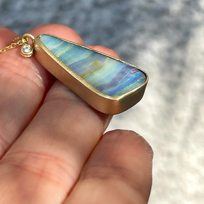 Gold opal necklace by NIXIN Jewelry shown in profile