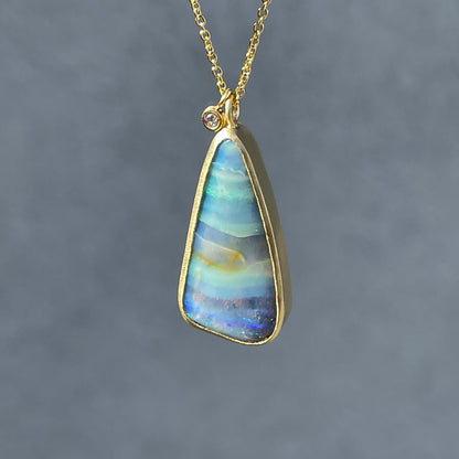 Opal and diamond necklace by NIXIN Jewelry suspended in sunlight