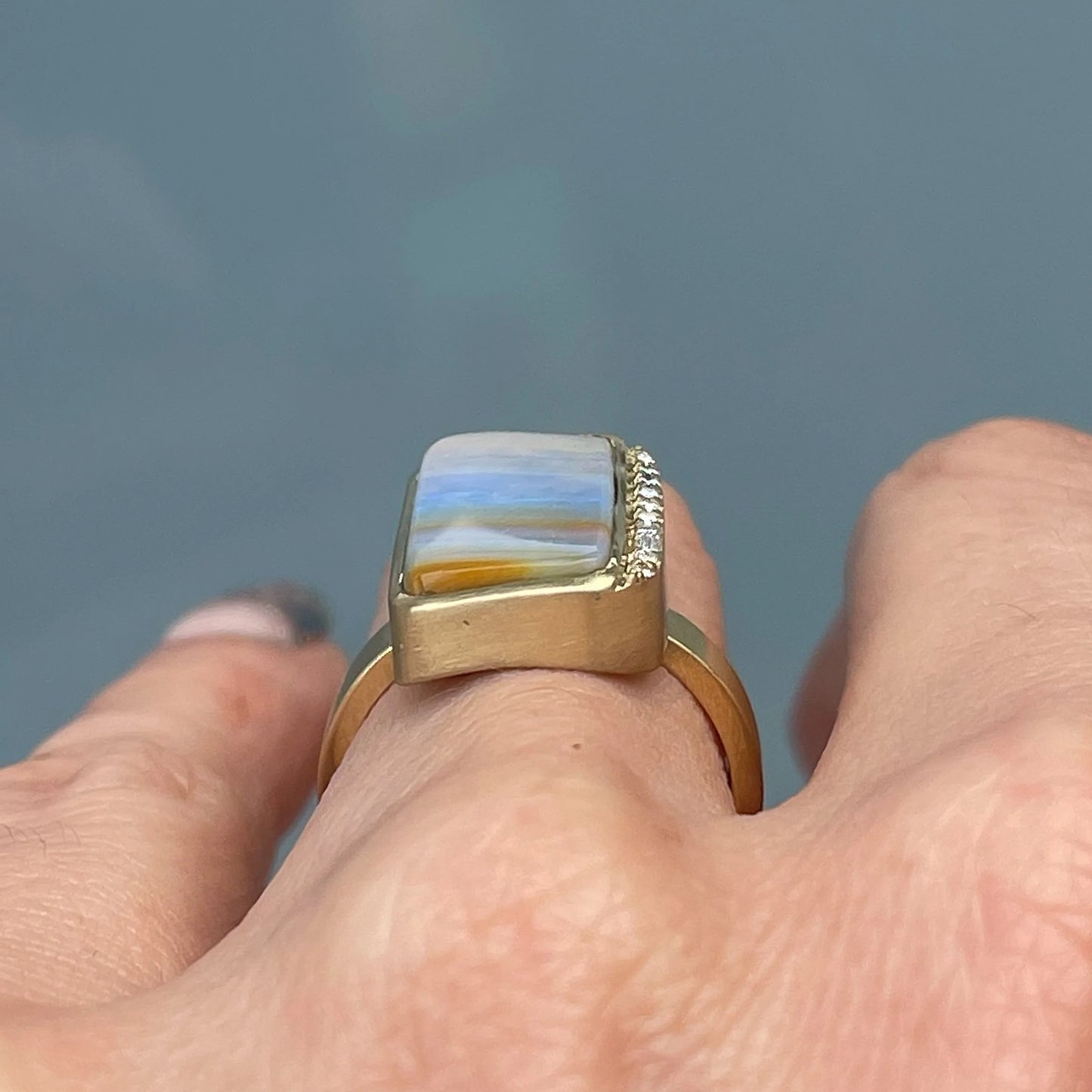 An Australian Opal Ring by NIXIN Jewelry modeled on the hand and shot to show the height of the ring when worn on the finger.