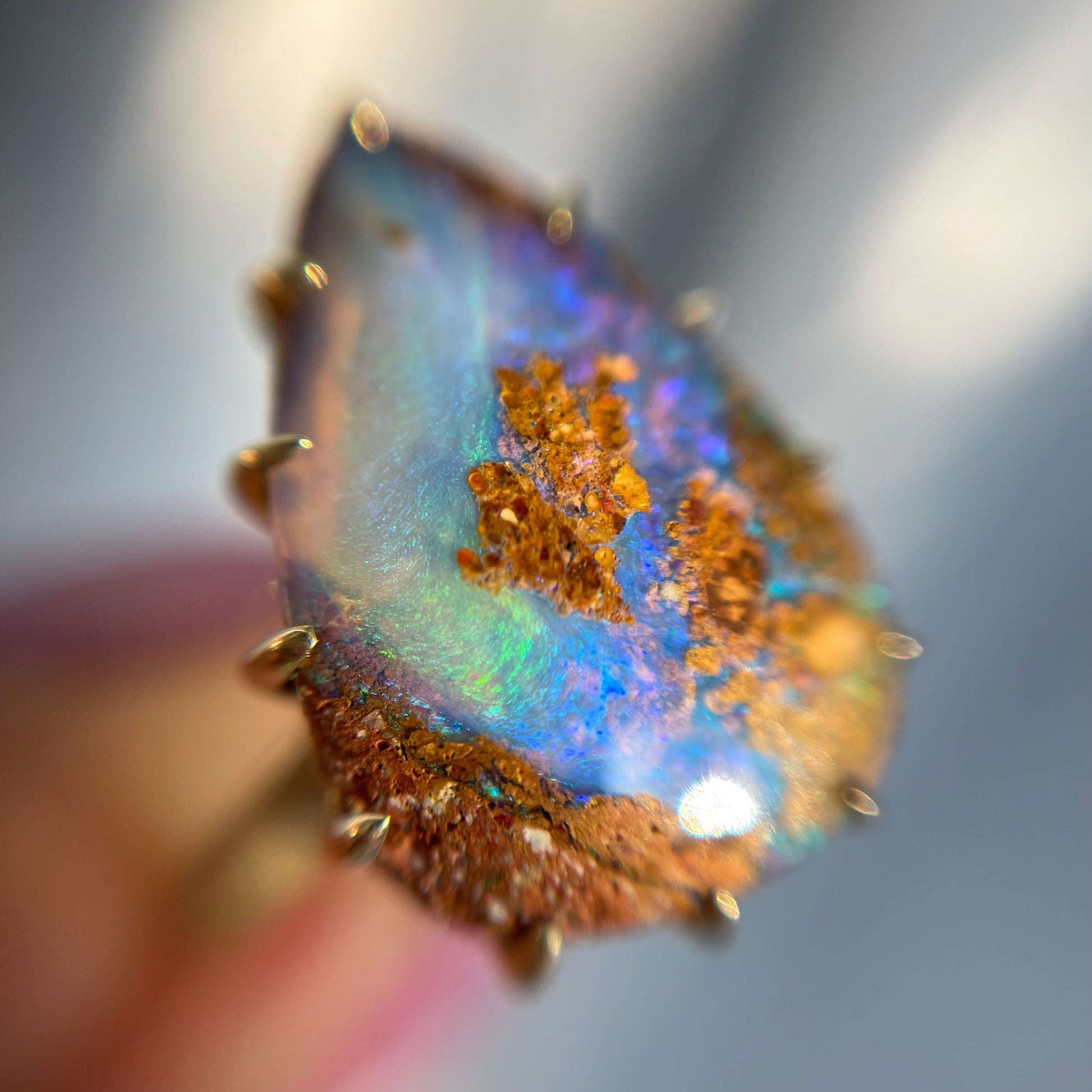 A NIXIN Jewelry Australian Opal Ring shot under magnification. A beautiful blue, green and purple opal ring.