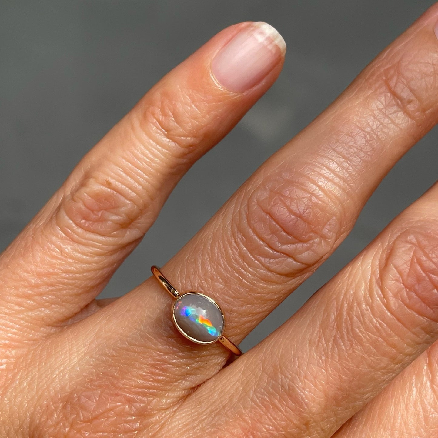 Shot on hand of rose gold opal ring by NIXIN Jewelry