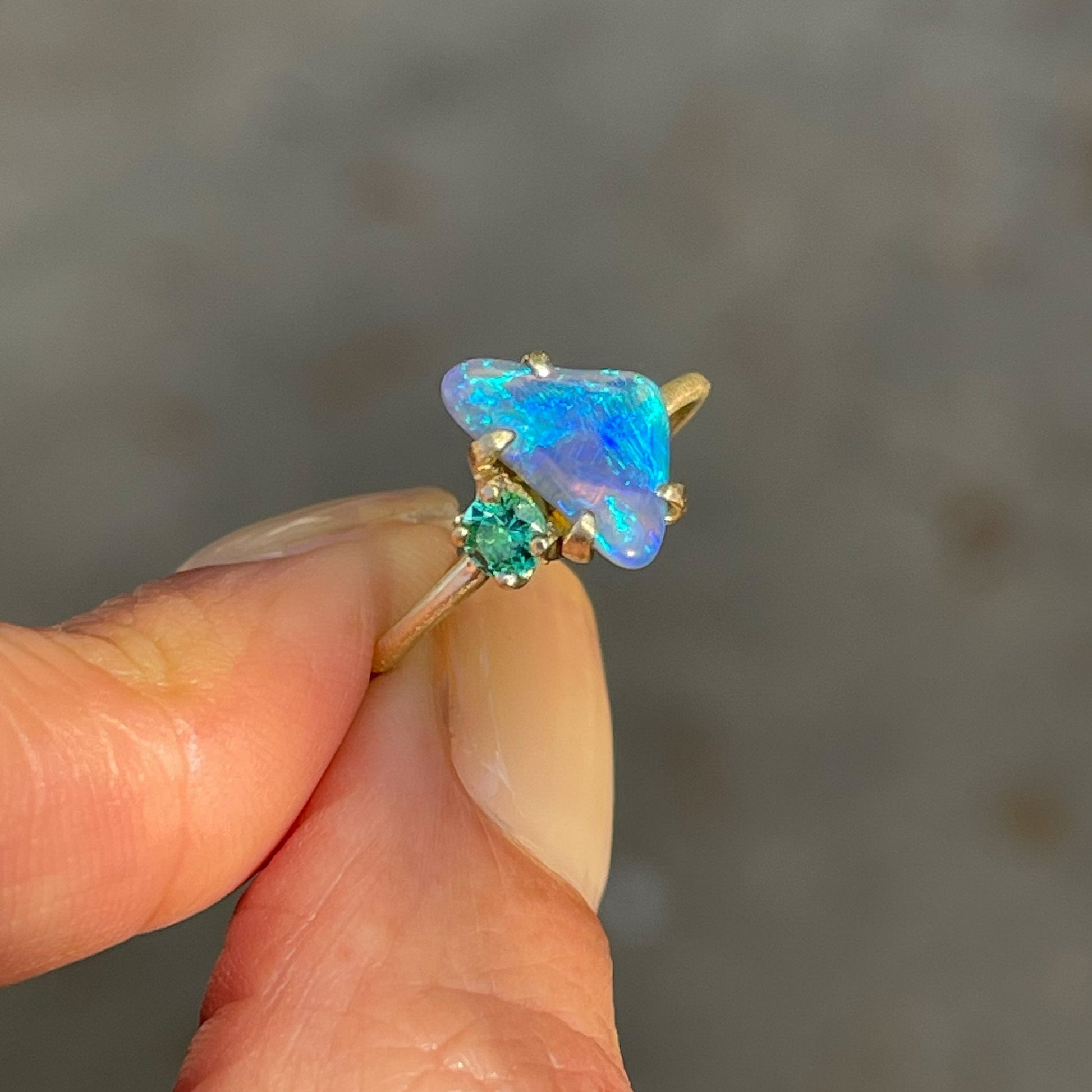 Australian opal ring with black crystal opal by NIXIN Jewelry held in sunlight