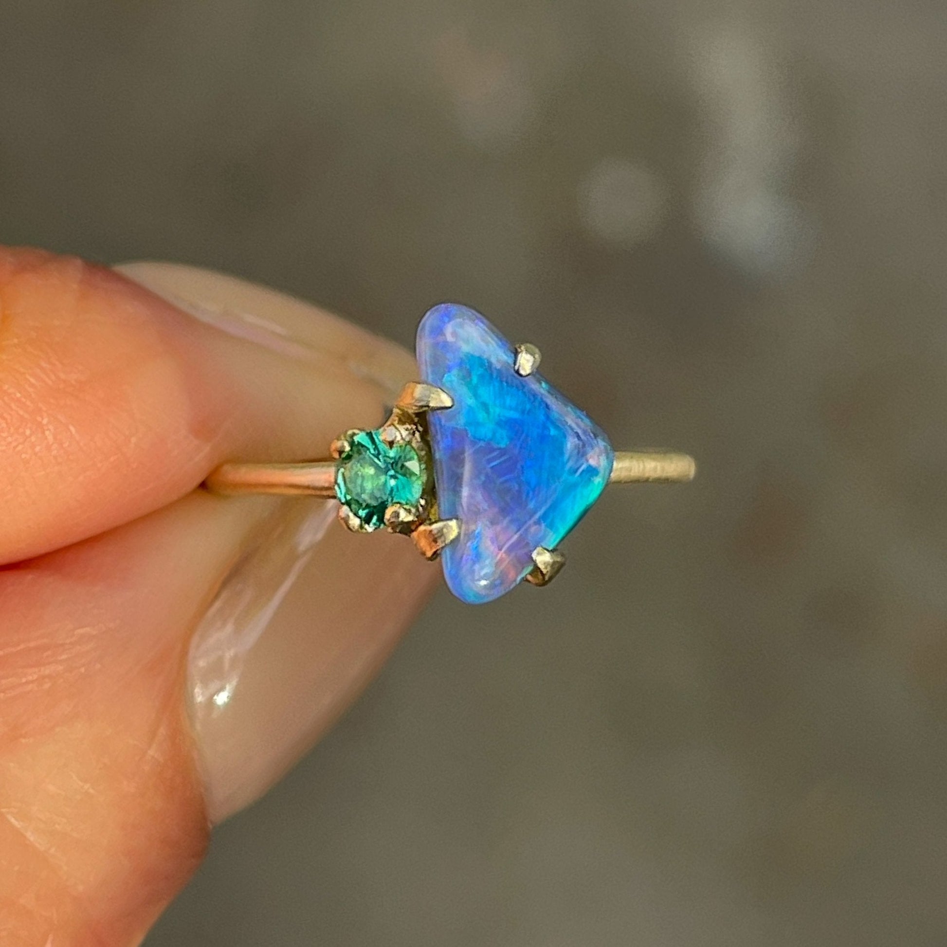 Australian black opal ring by NIXIN Jewelry held in fingers