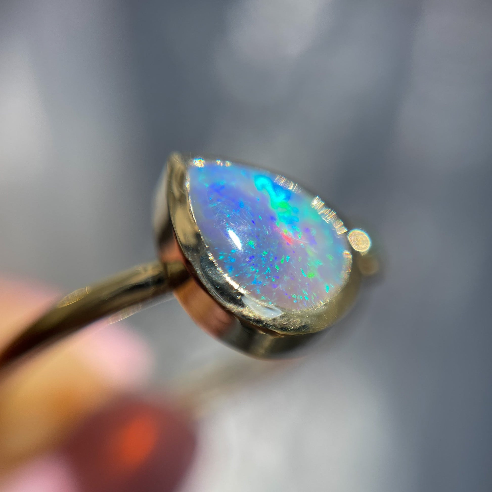 Magnified shot of an Australian Opal Ring by NIXIN Jewelry. A 14k gold pear shaped opal ring.